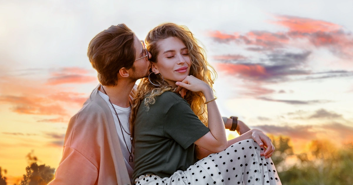 couple sitting down. Guy kissing the girl