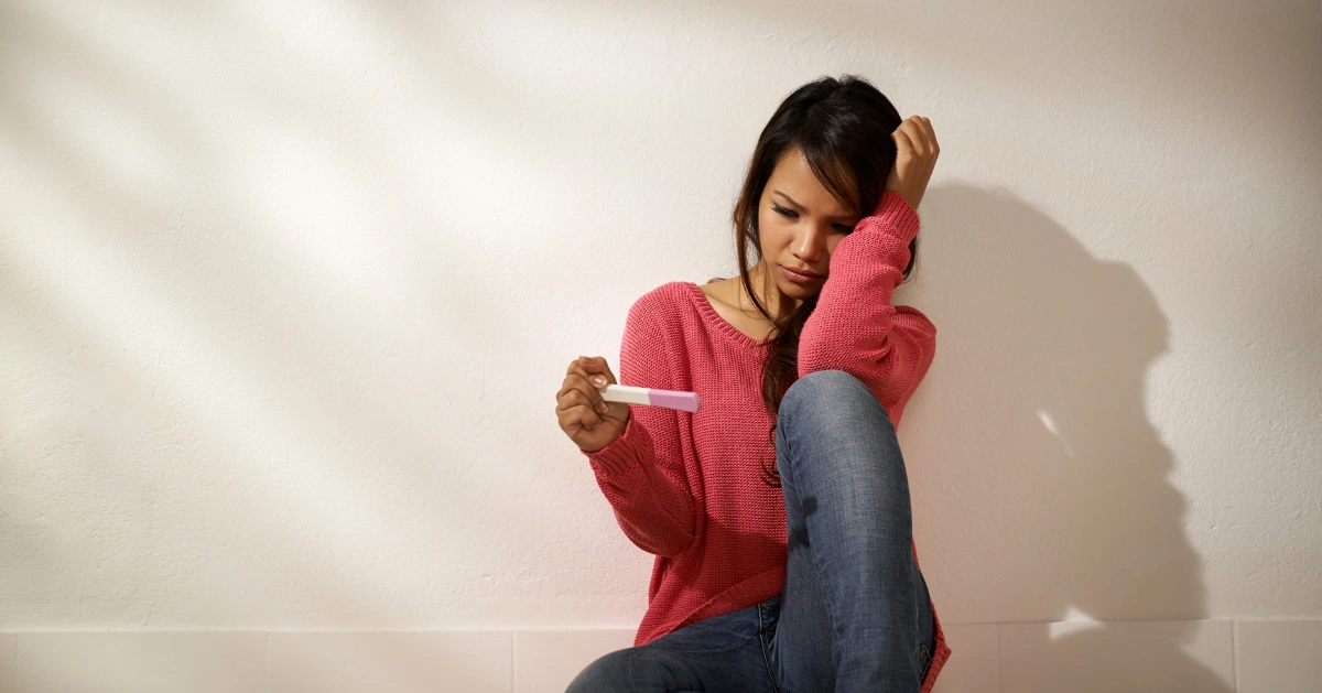 A girl seeing the positive result on her pregnancy test