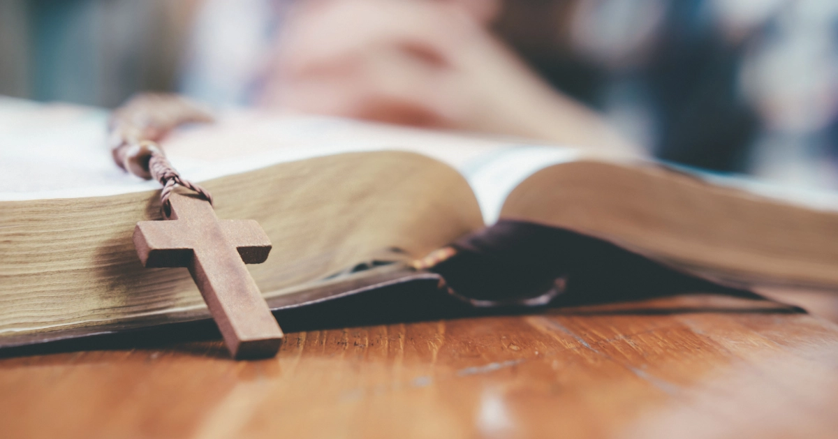 An open bible with a cross over it