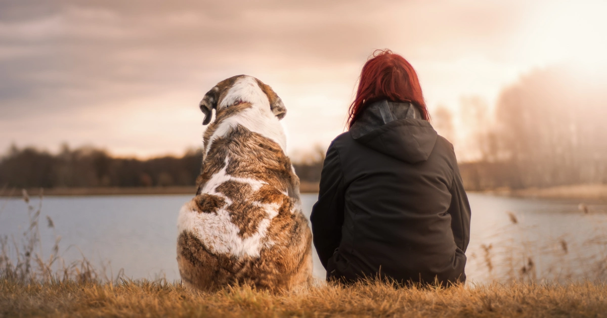 A girl sitting down with her dog