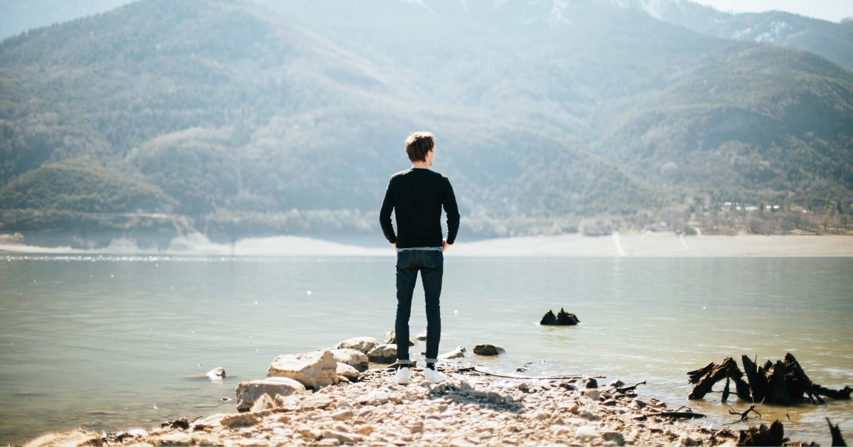 a guy looking out at the lake