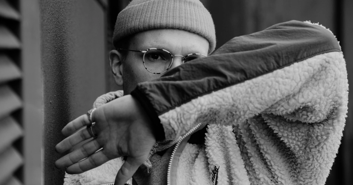 Man holding his arm out across his face.