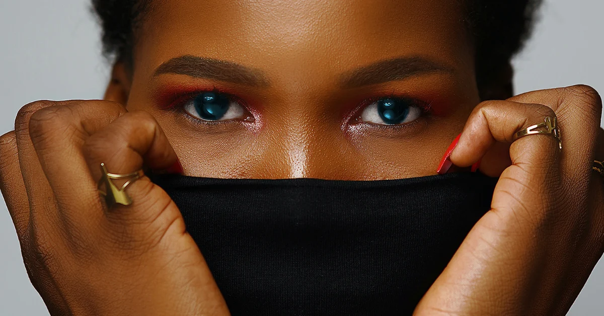 Picture of a lady covering her mouth with her top