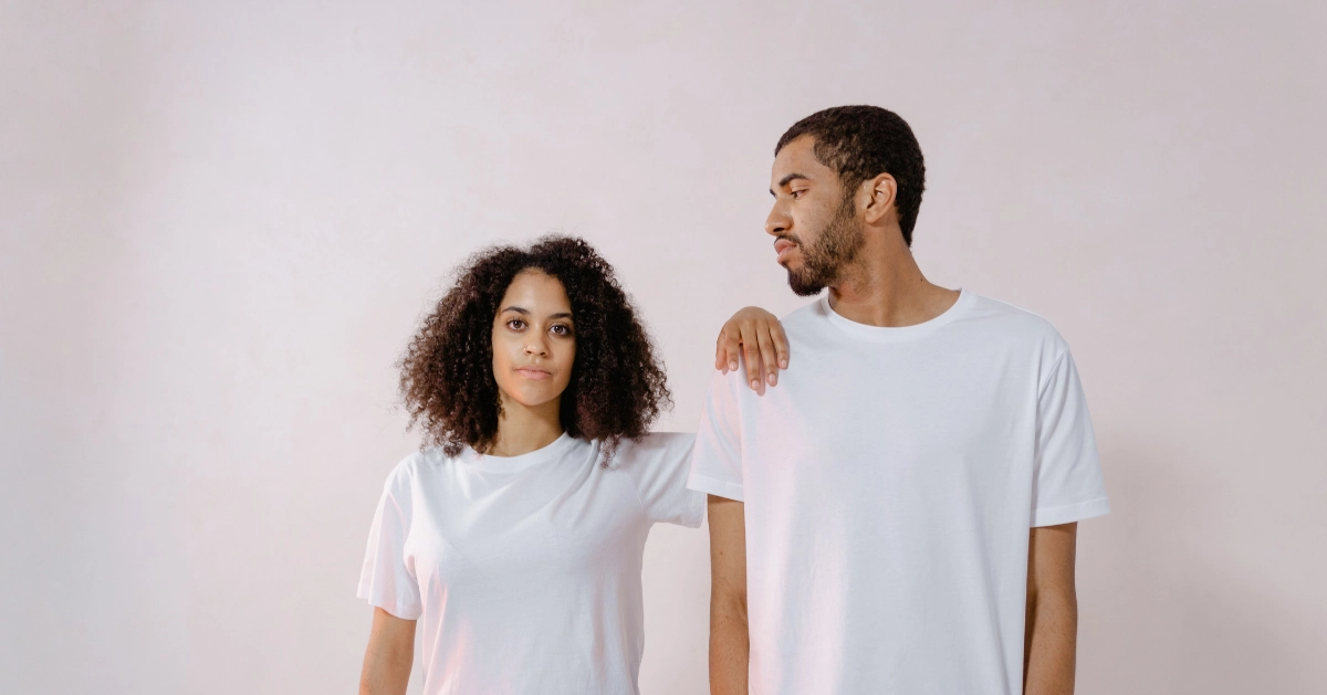 Girl in white t-shirt with her arm on a guy with a white t-shirt.