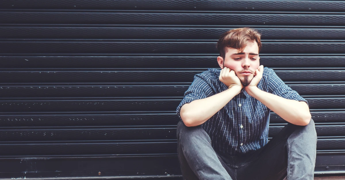 a guy sitting on the floor looking sad