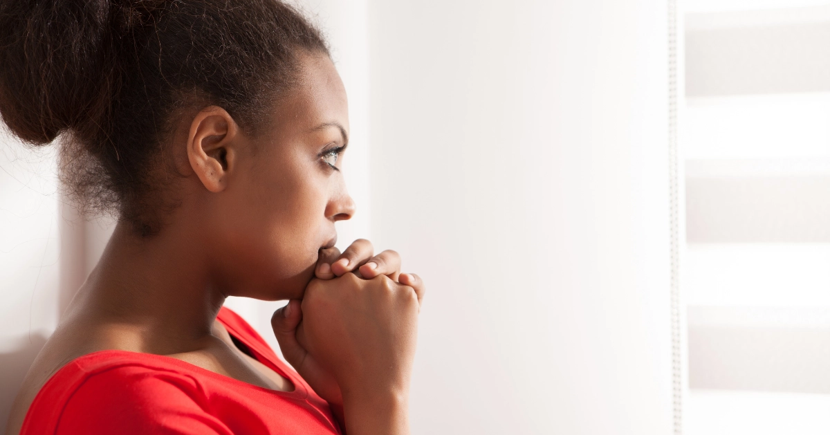 a girl sitting in front of her window depressed