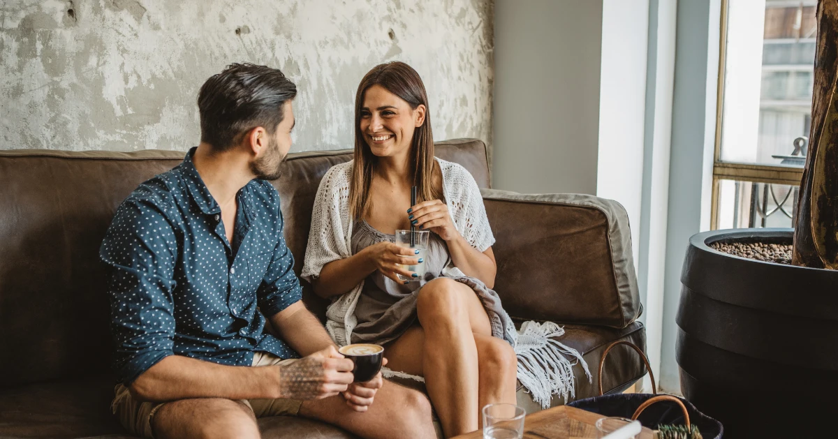 a couple sitting on the couch laughing