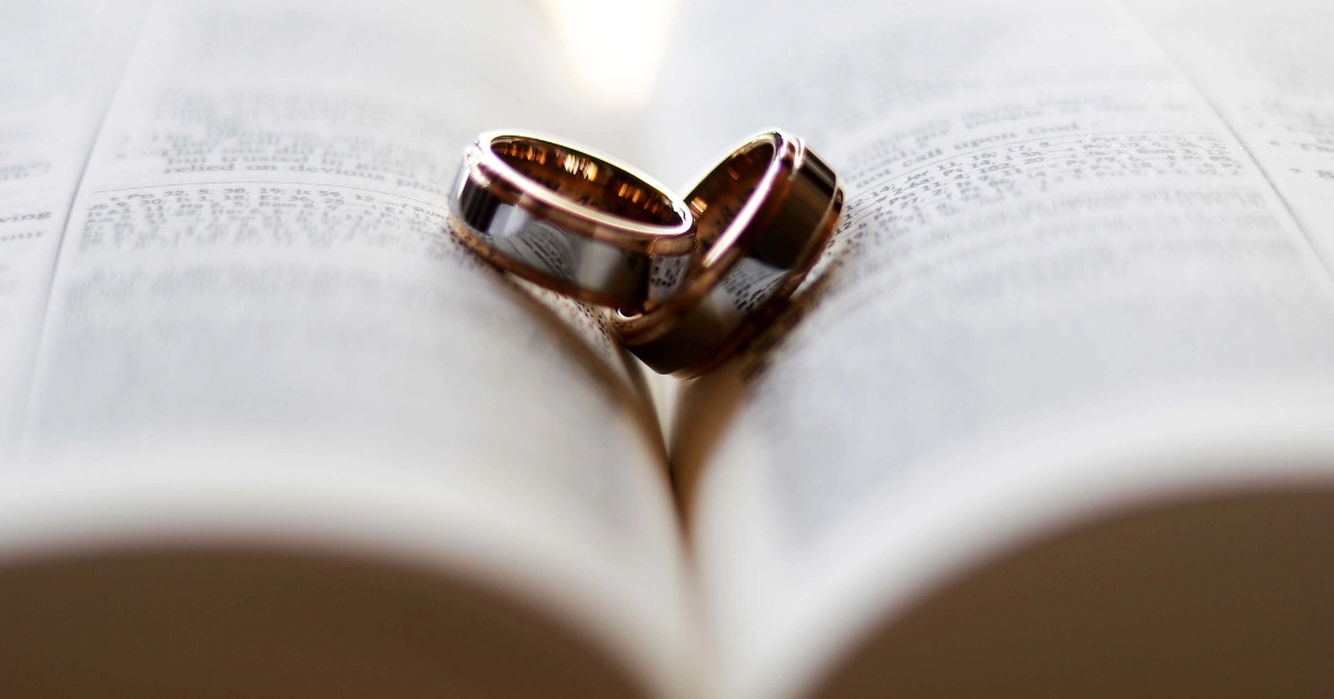 wedding bands laying on a bible