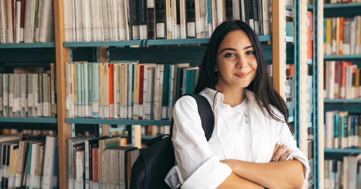 a teen in the library with her backpack on her shoulder