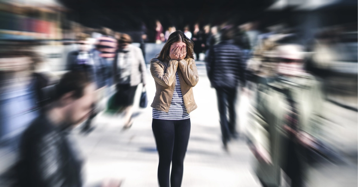 a girl standing in the middle of a crowded spot panicking