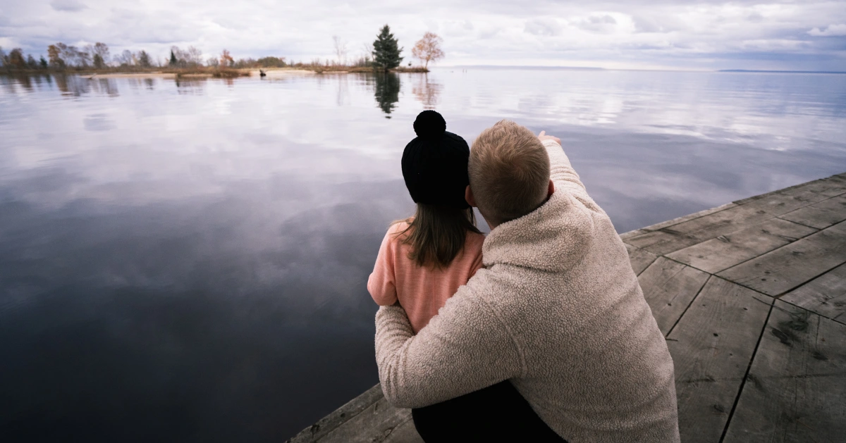 Father and daughter looking out on a lake