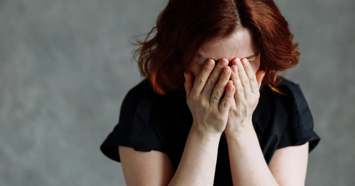 a lady covering her face crying