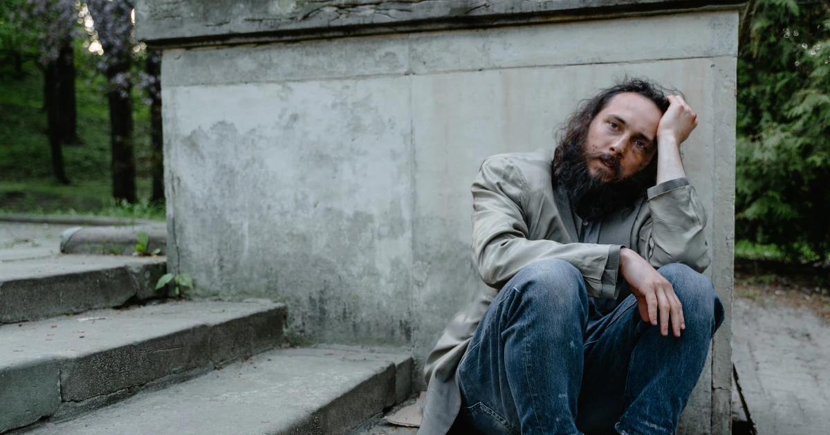 a man sitting on the floor looking sad