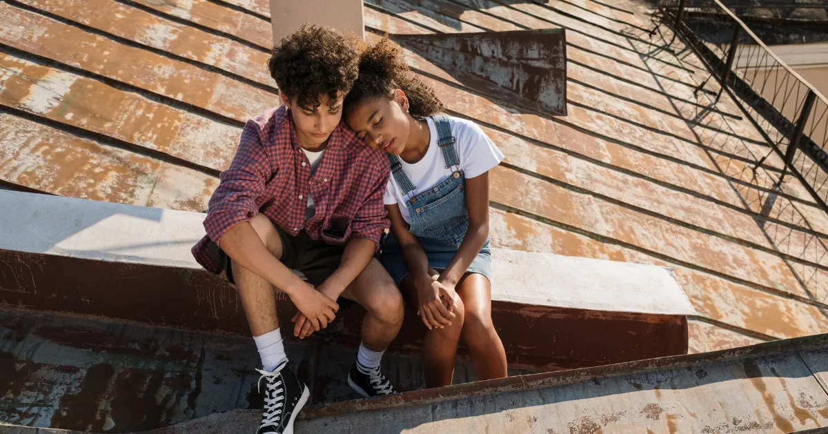 teens sitting on a roof building
