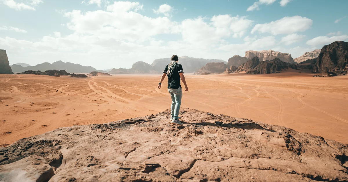 A guy standing on a rock cliff