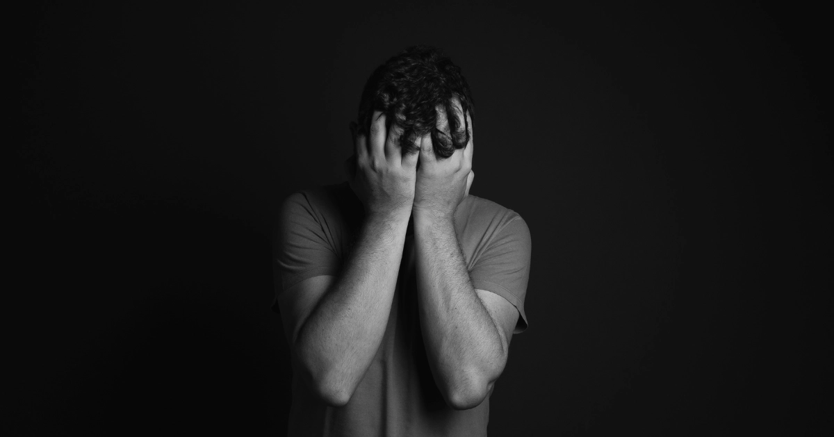 A guy covering his face