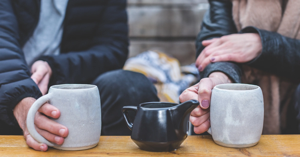 A couple sitting down having some tea.