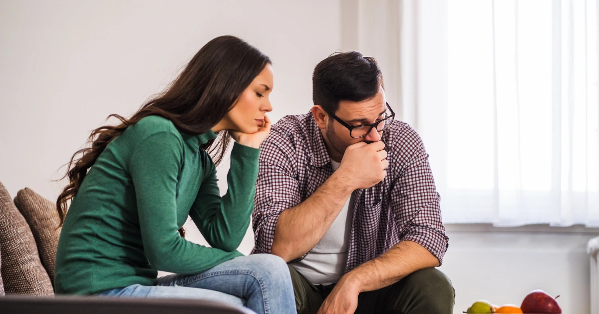 a couple sitting on the couch sad