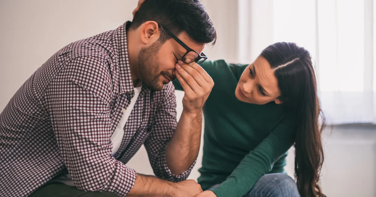 a guy stressed out while his partner is comforting him