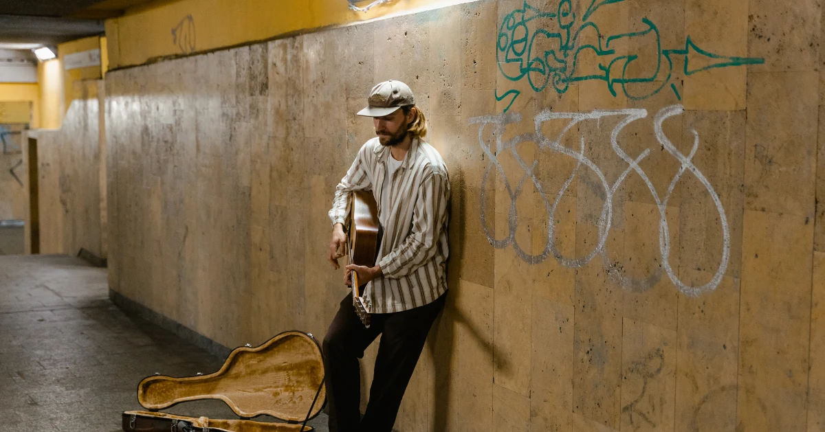 Sad guy in the subway playing guitar