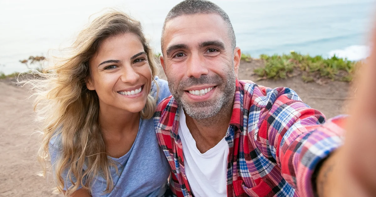 A couple smiling outside.