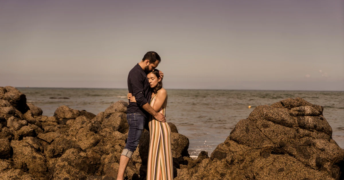 Couple embracing by the ocean.