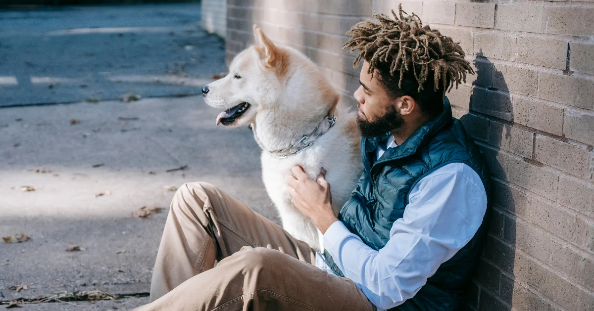 Guy sitting with his dog
