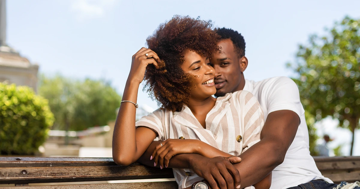 a couple hugging on a park bench