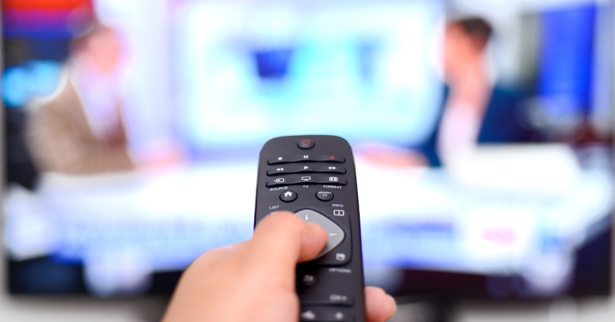 someone holding a remote control for the TV
