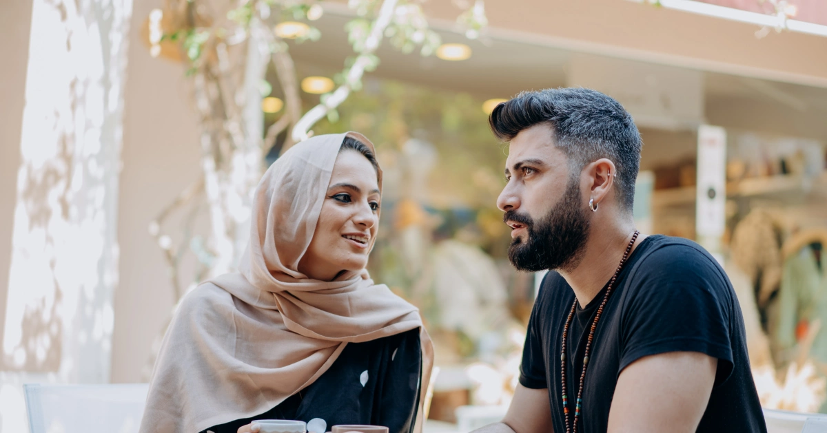 A man and a woman talking outside.