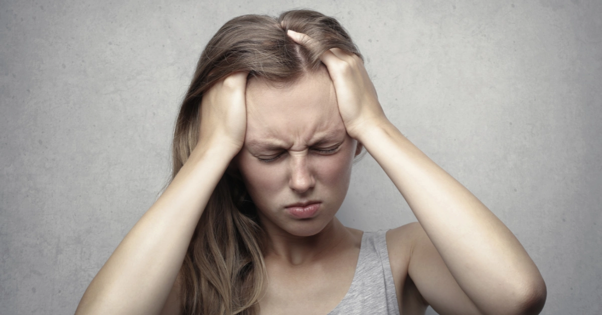 Girl holding her head frustrated with jealously.