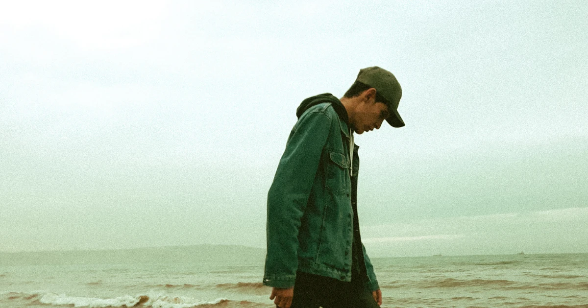 Teen boy outside by the beach.