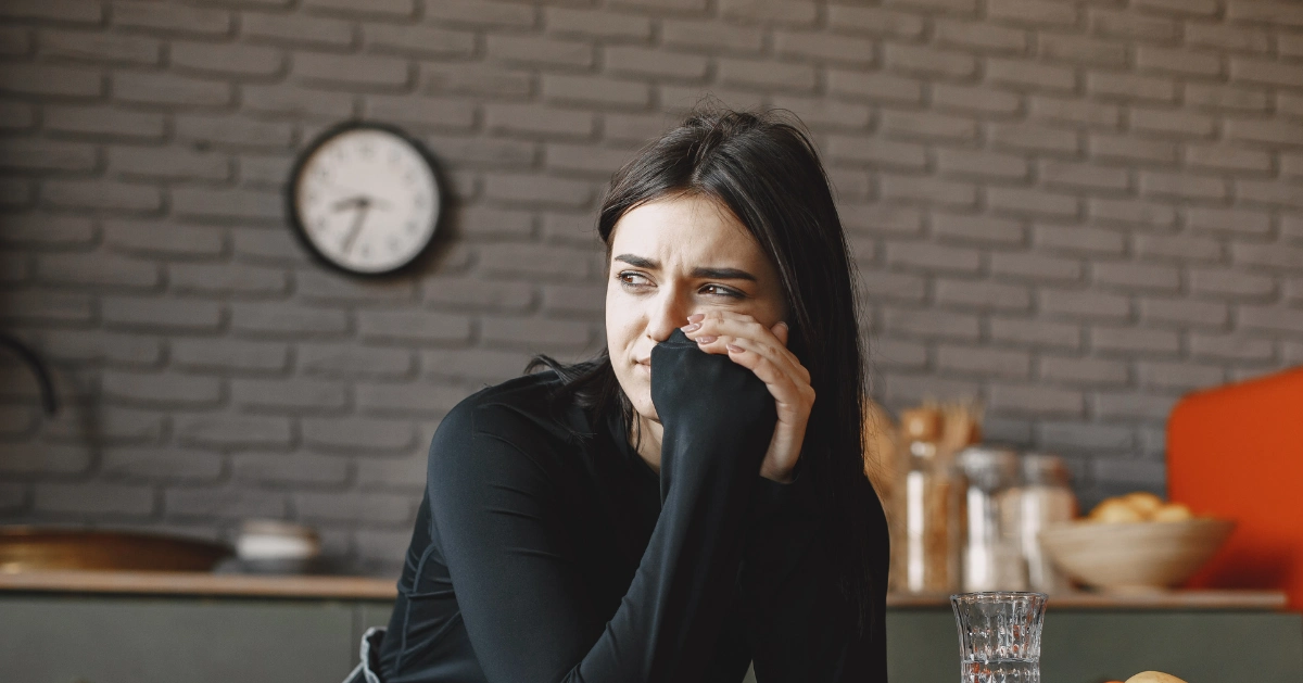 Girl at a coffee shop looking worried.