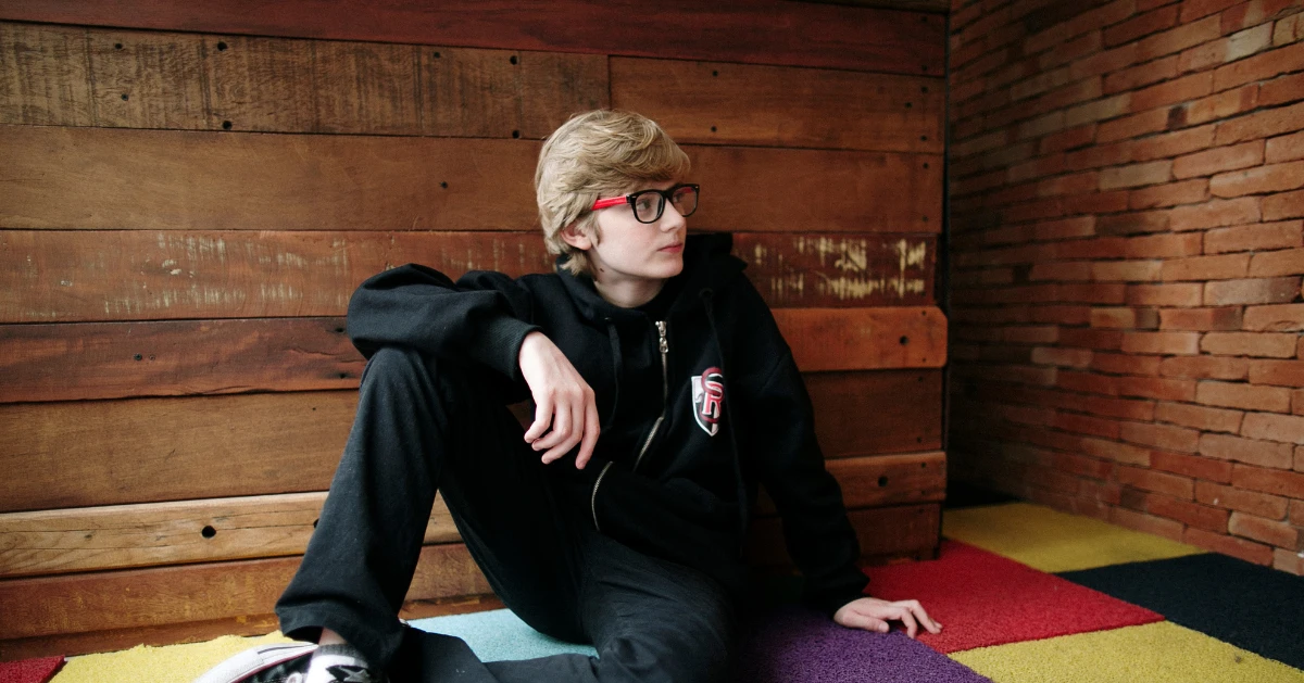 Teen boy sitting on a colorful rug