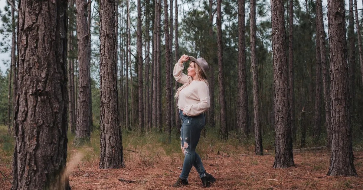 girl in the woods looking up
