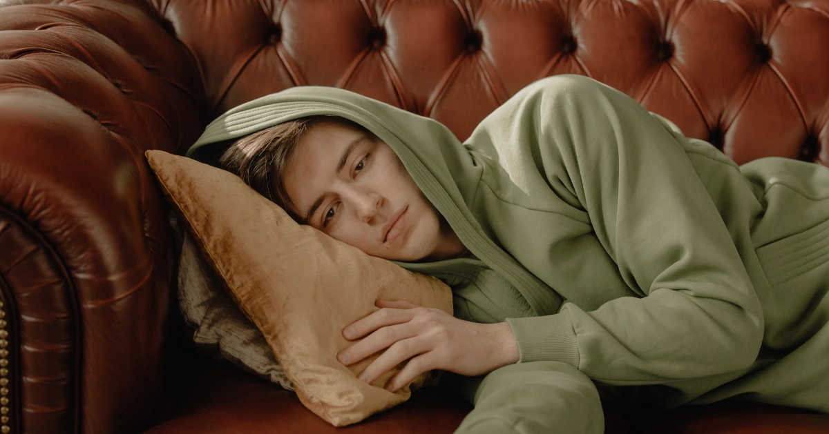Depressed man laying on the couch.