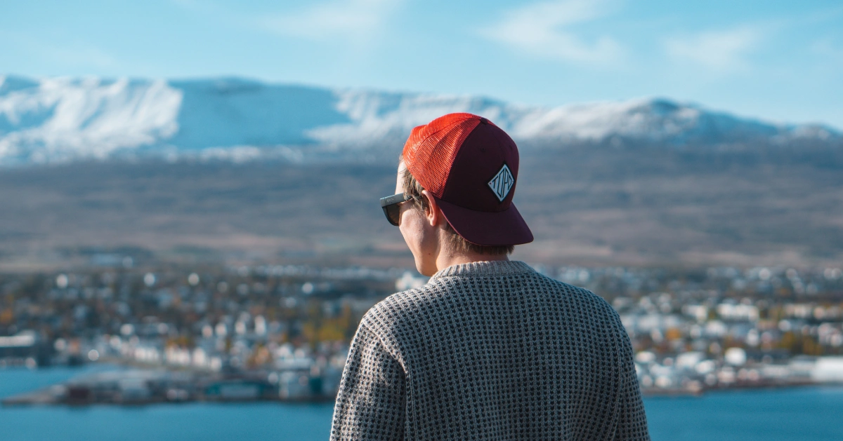 Man with a red hat looking in the distance.