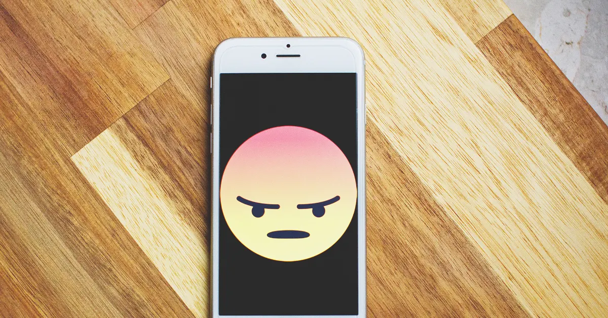 Anger emoji on a iPhone on a table.
