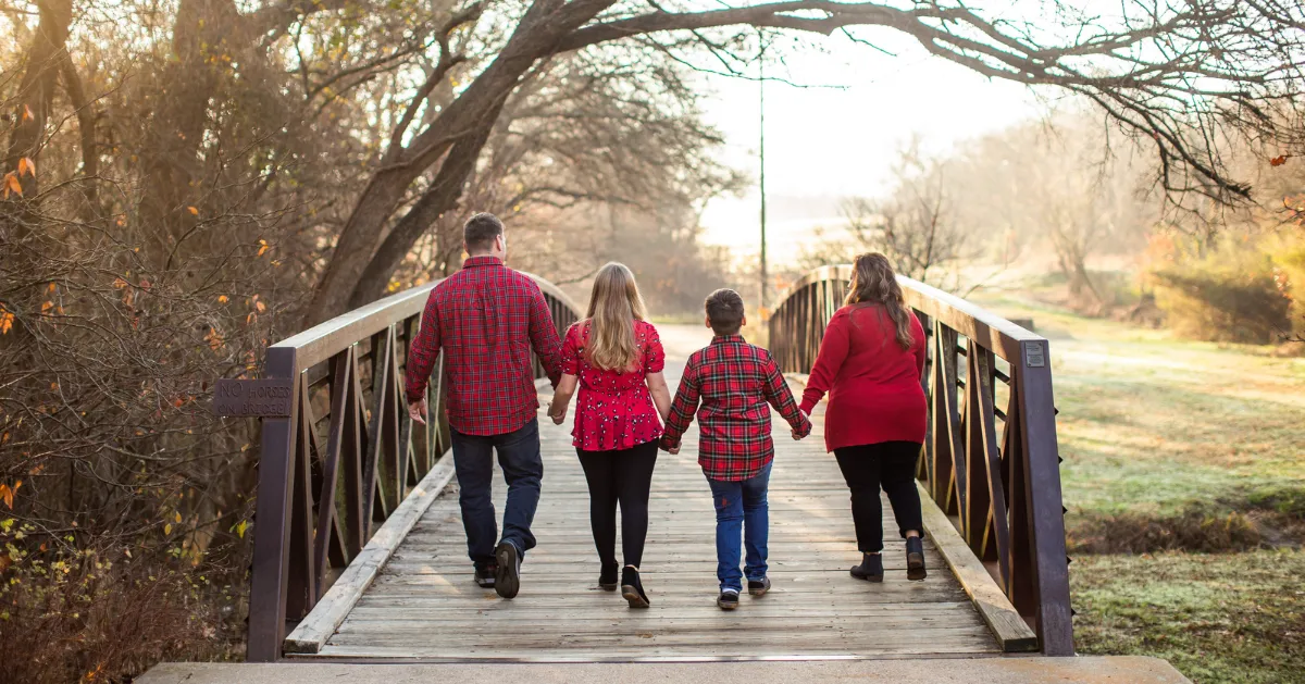 parents walking on a bridge in the countryside with children